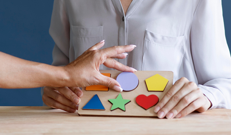 A nurse assisting a resident with communication exercises, highlighting the speech therapy component of Post-stroke support for elderly near Delhi.